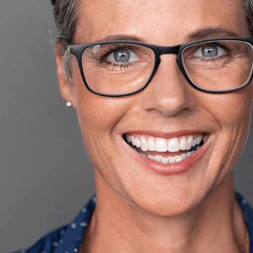 Healthy, happy middle aged woman wearing white, natural looking dentures